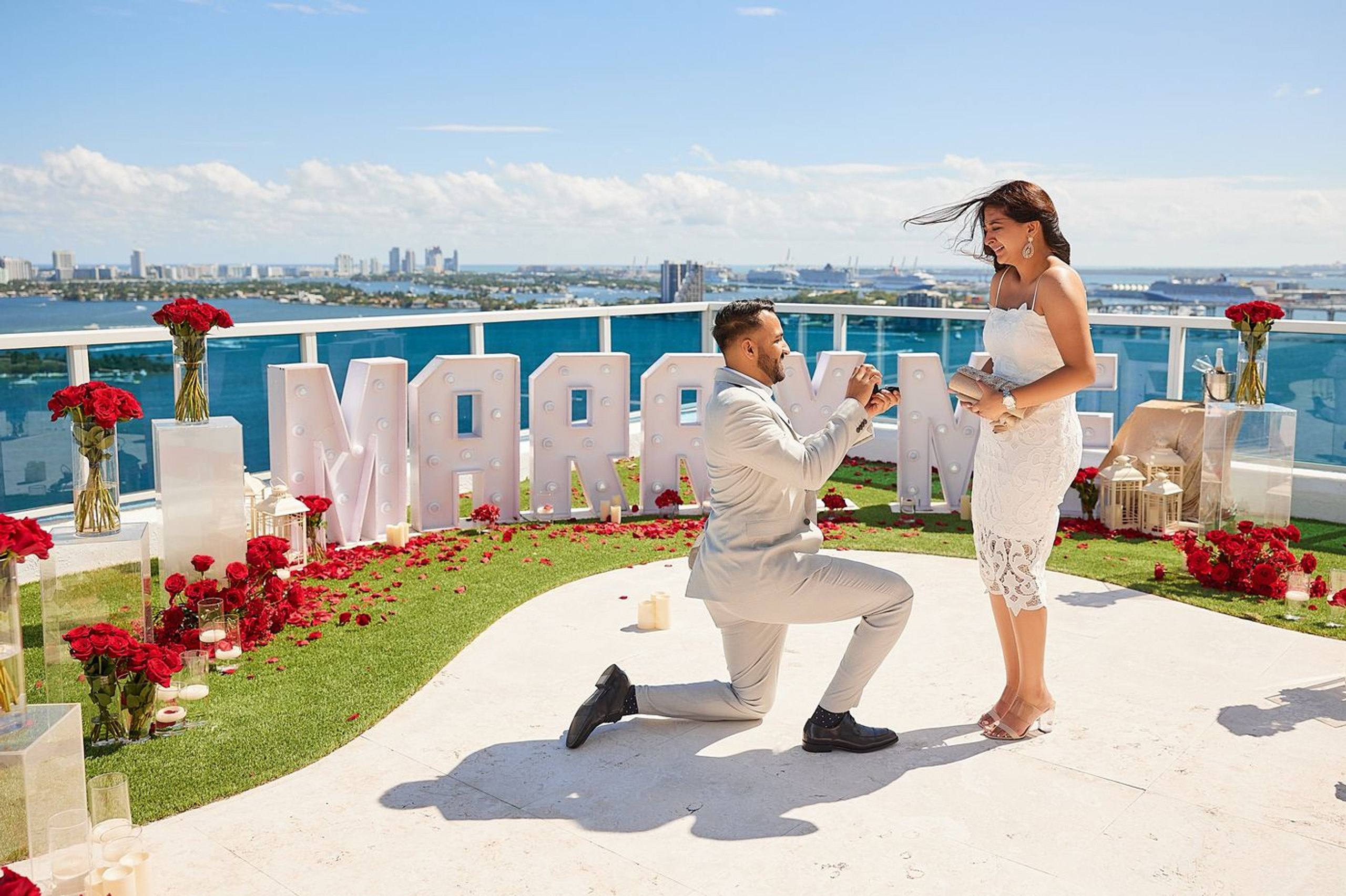 Couple beside red letters on a sunny beach