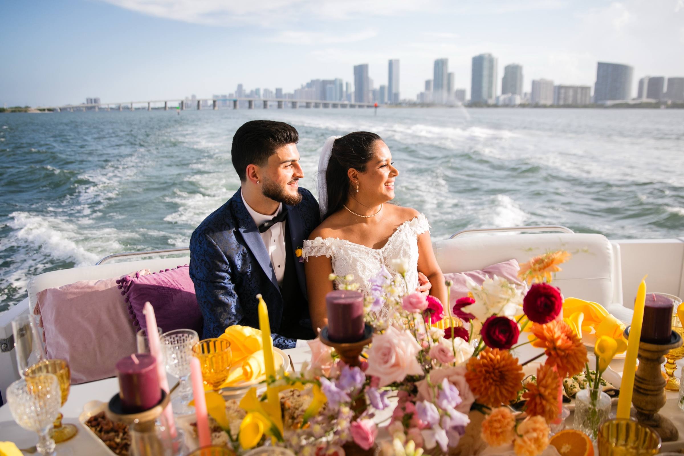Couple on a boat with bright florals and the Miami skyline behind them