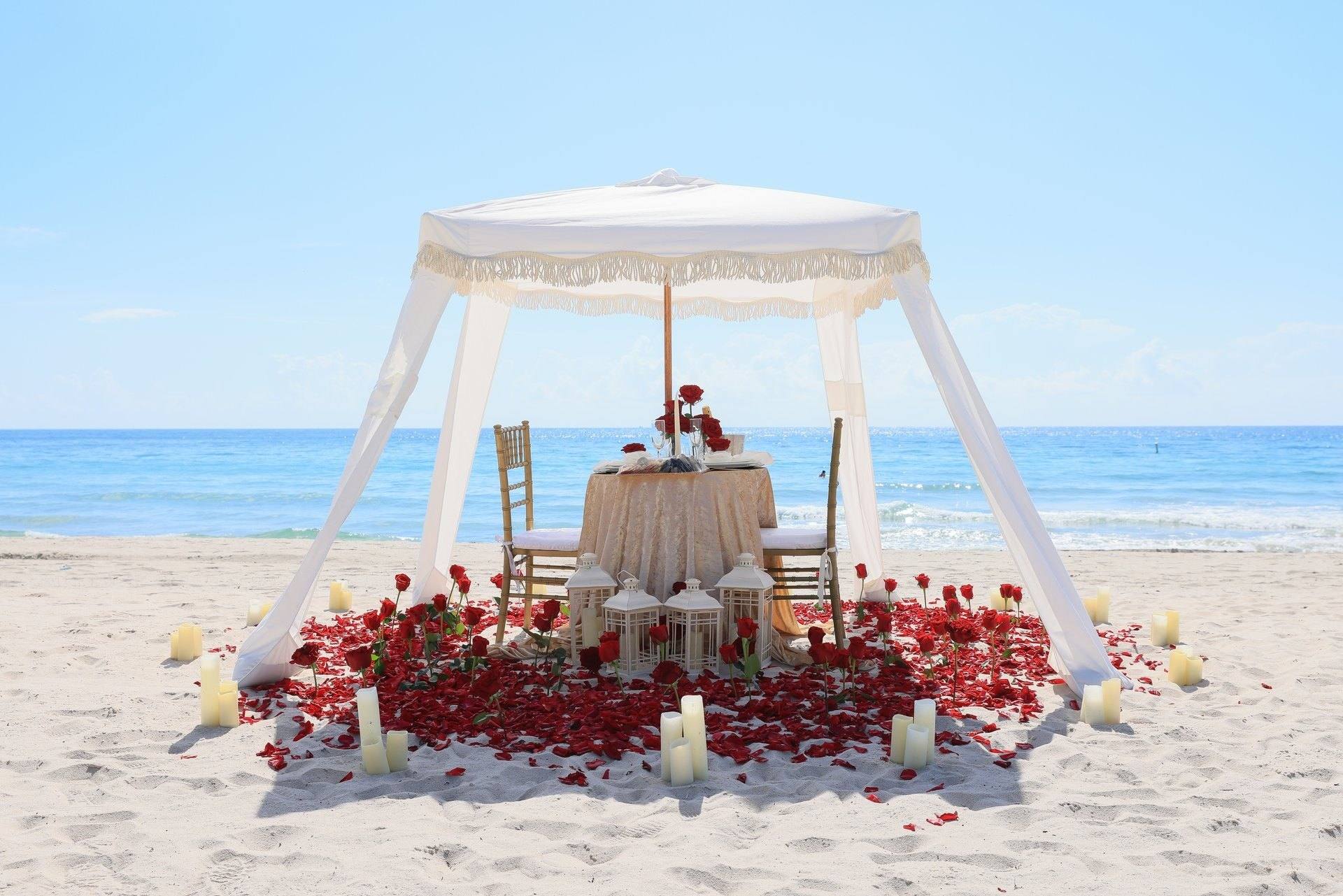 Beach cabana dressed with red roses and candles