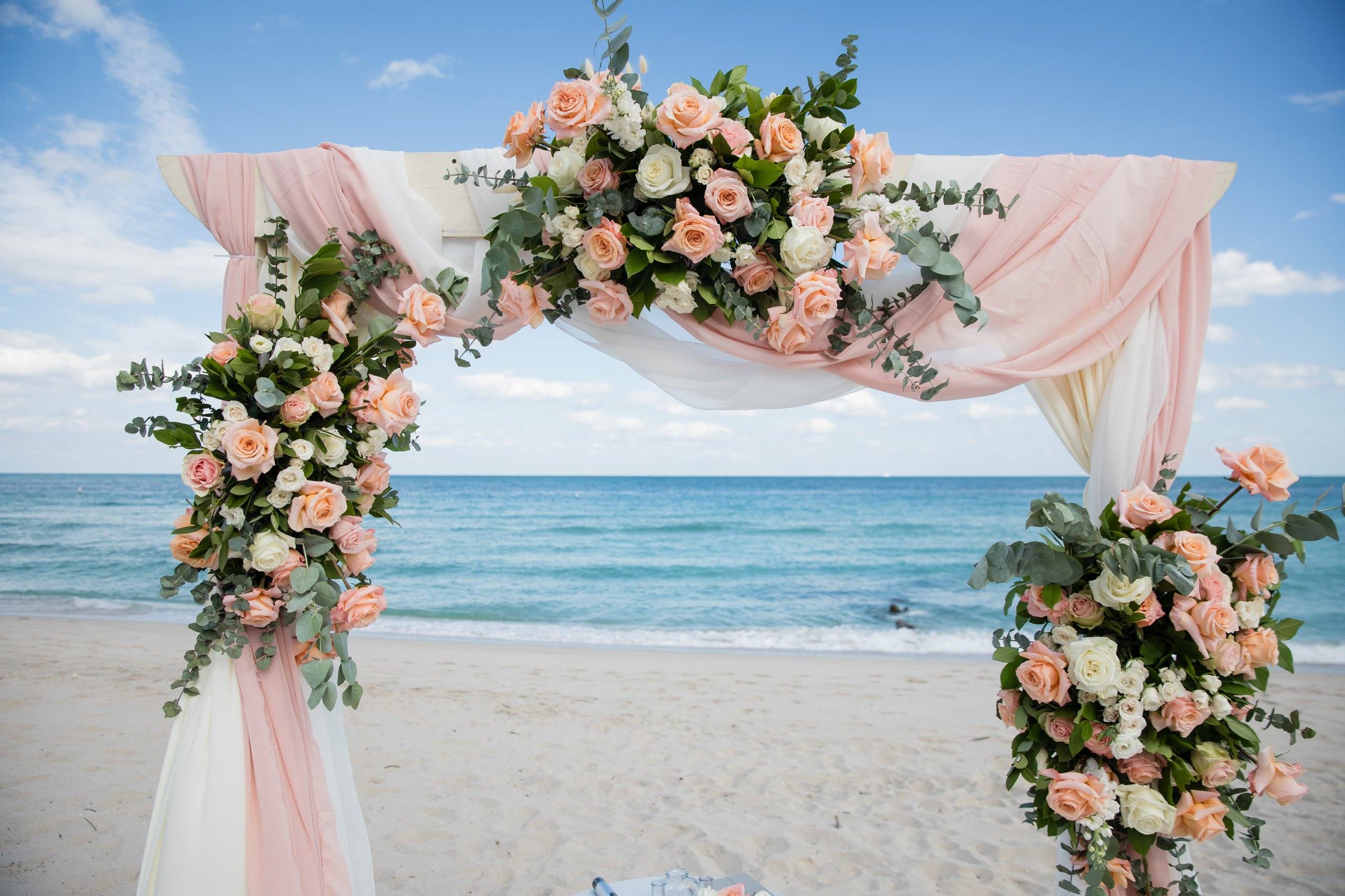 Blush floral arch set on the beach