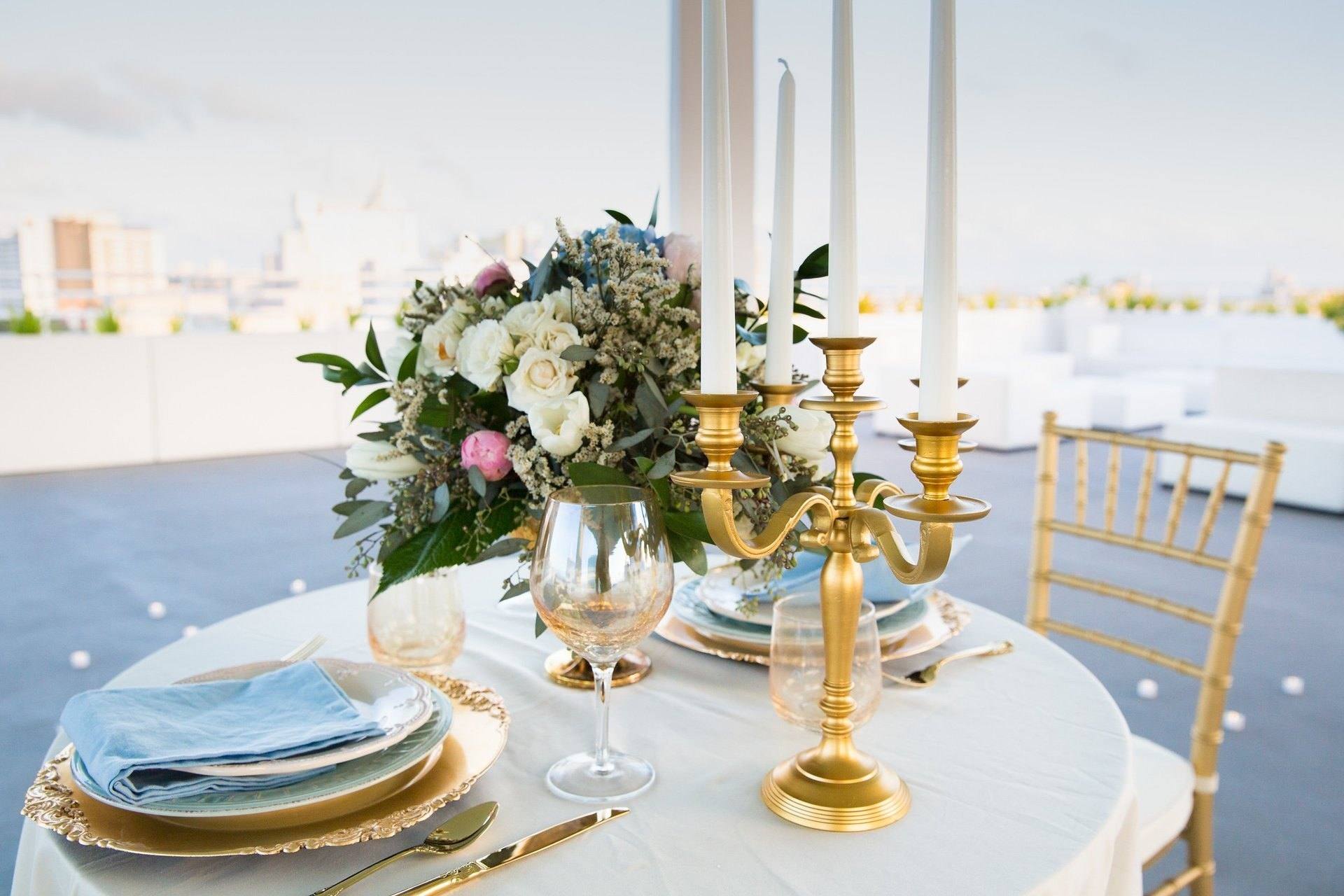 Table styled with gold candelabras and roses