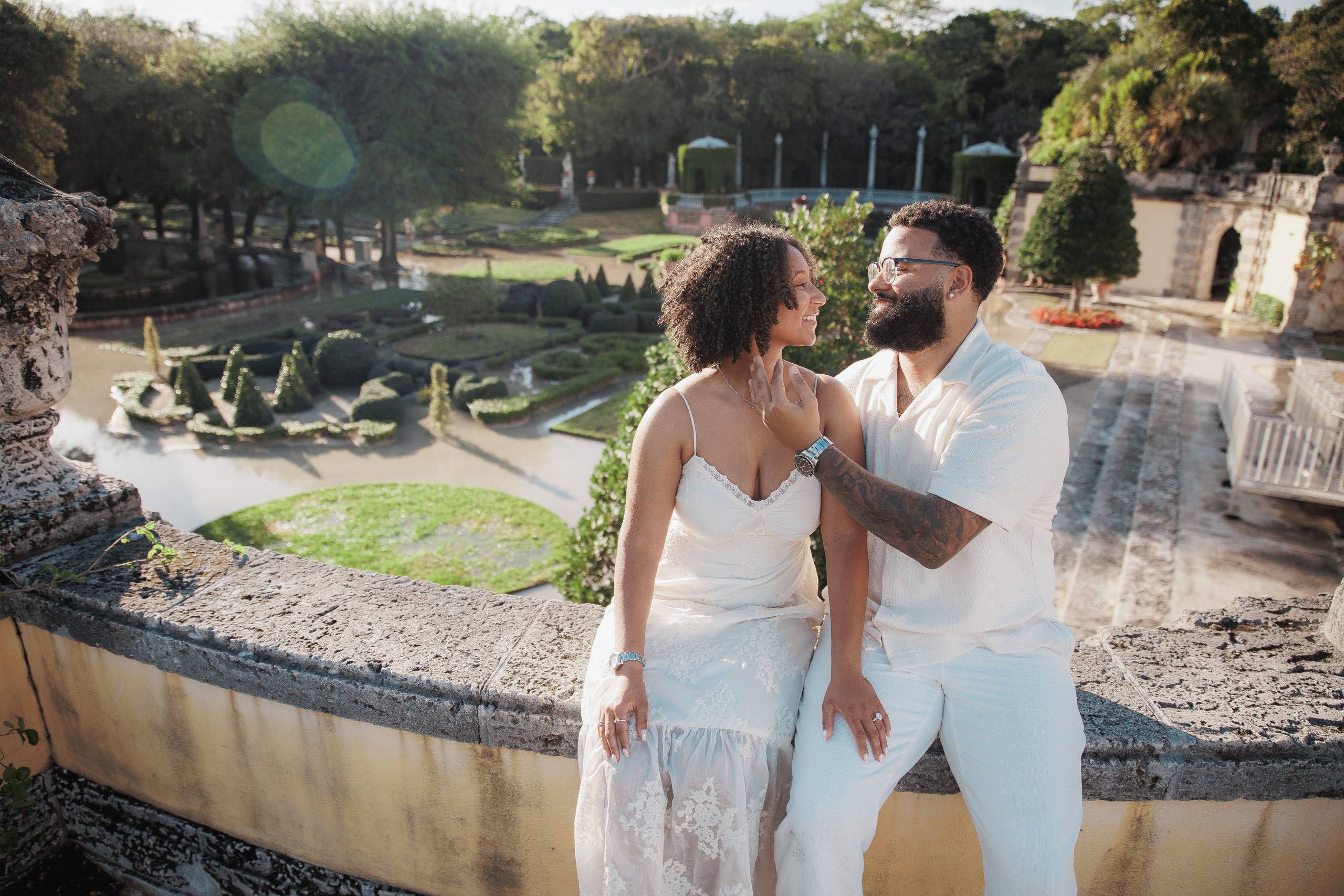 Couple walking beside a stone fountain in a formal garden